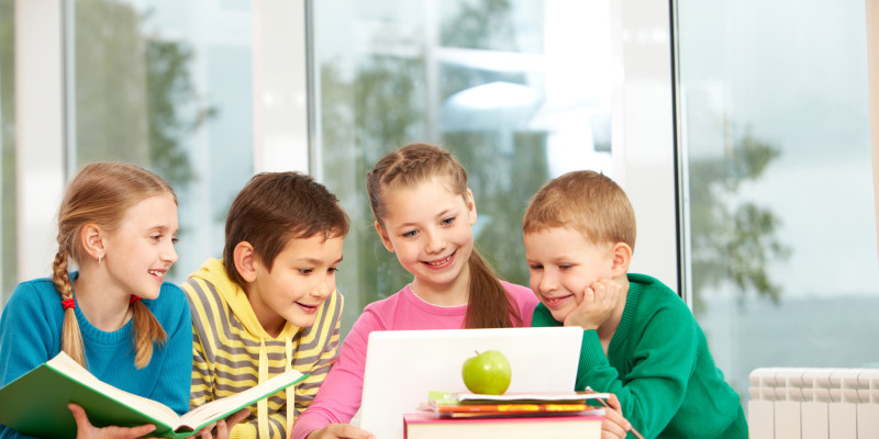 group schoolchildren looking laptop classroom